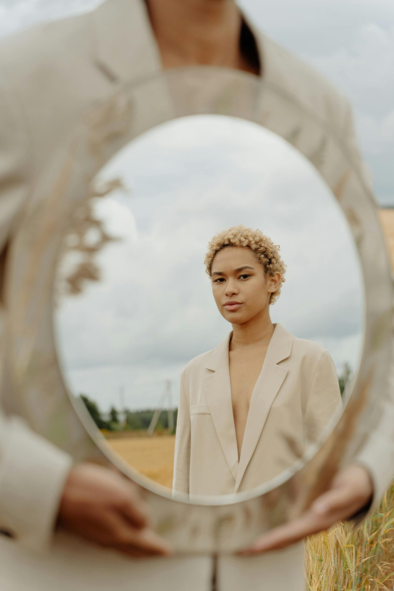 Stylish portrait using a mirror outdoors for a conceptual twist.